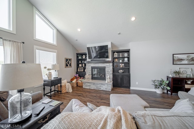 living room featuring a stone fireplace, a textured ceiling, dark wood-type flooring, and high vaulted ceiling