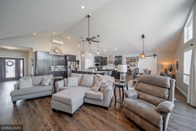 living room with a barn door, dark hardwood / wood-style floors, high vaulted ceiling, and ceiling fan