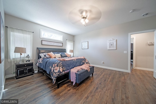 bedroom with dark hardwood / wood-style flooring, a textured ceiling, and ceiling fan