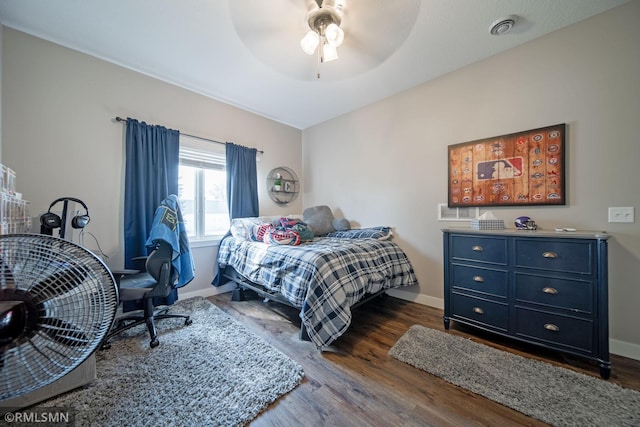 bedroom with dark hardwood / wood-style flooring and ceiling fan