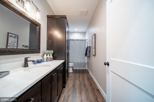 bathroom featuring wood-type flooring, vanity, and toilet