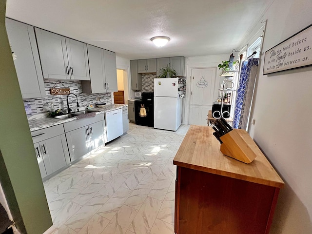 kitchen featuring gray cabinets, white appliances, sink, and backsplash