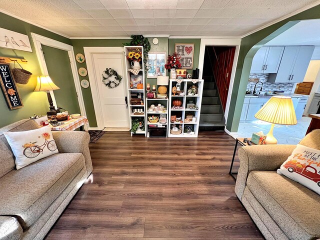 living room with dark wood-type flooring and ornamental molding