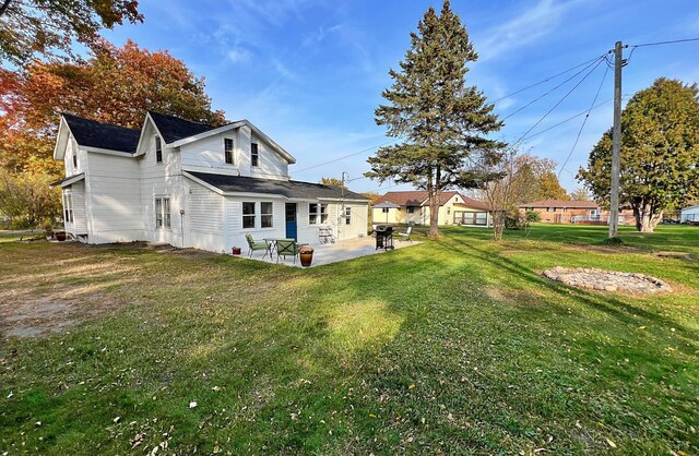 back of property with a patio and a yard