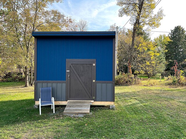 view of outbuilding with a yard