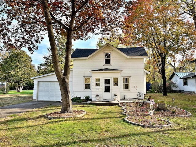 view of front of home with a front yard and a garage