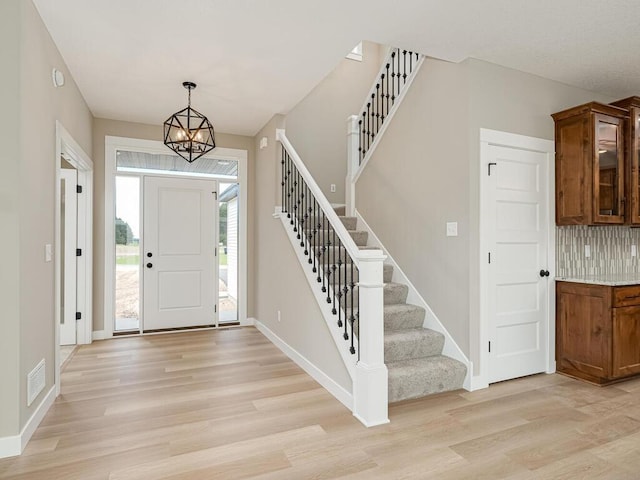 entryway with a notable chandelier and light hardwood / wood-style flooring