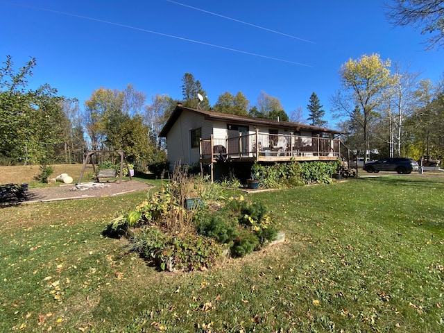 back of property featuring a wooden deck and a yard