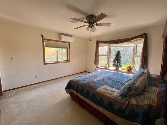 bedroom with ceiling fan, carpet floors, and a wall unit AC