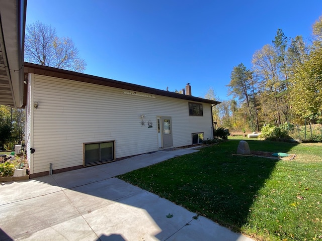 rear view of house with a patio and a lawn