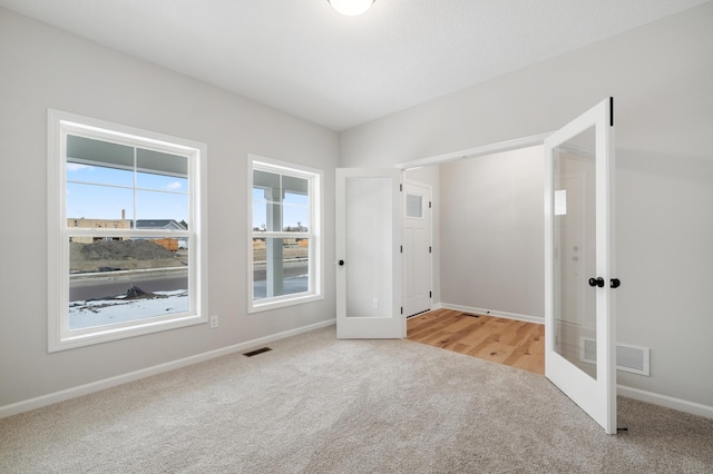 carpeted empty room with french doors