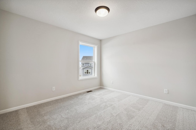 spare room with carpet flooring and a textured ceiling