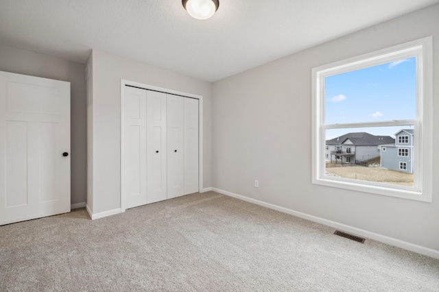 unfurnished bedroom featuring carpet floors and a closet