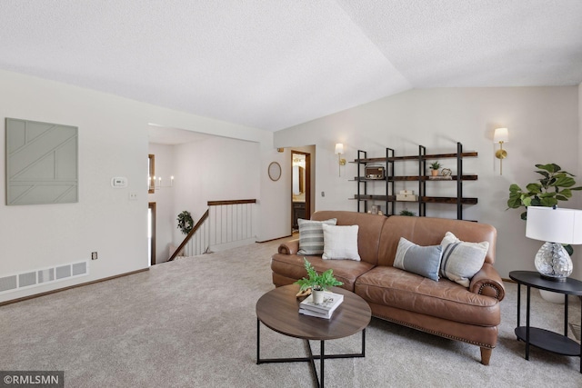 living area featuring lofted ceiling, light carpet, visible vents, and a textured ceiling