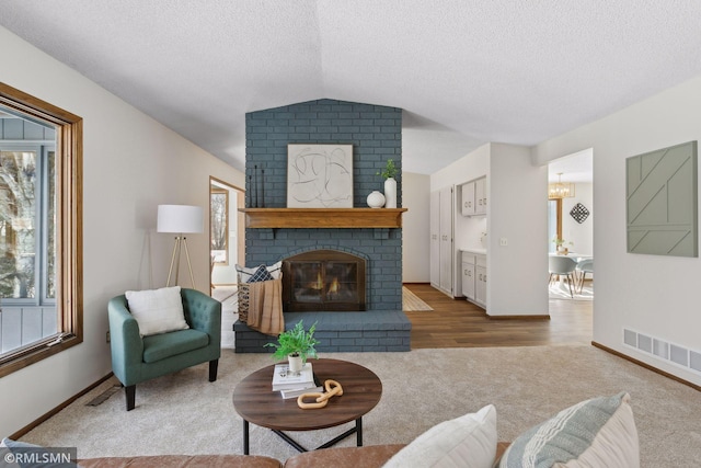 living room featuring plenty of natural light, a brick fireplace, and visible vents