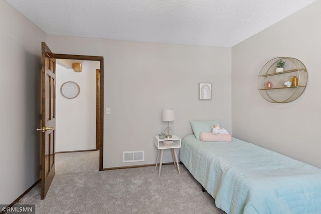 bedroom with baseboards, visible vents, a textured ceiling, and light colored carpet