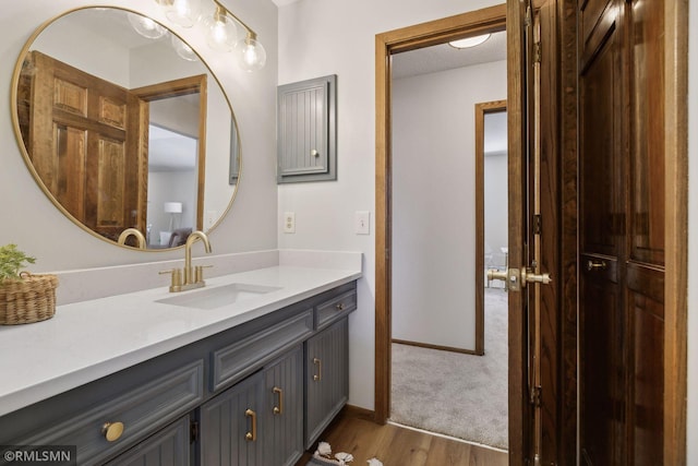 bathroom with baseboards, wood finished floors, and vanity