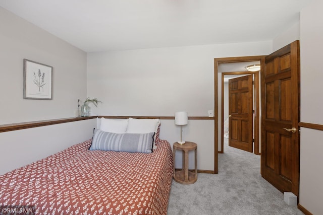 bedroom featuring light carpet and baseboards