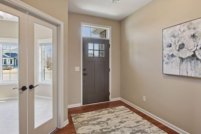 foyer entrance featuring dark wood finished floors, french doors, and baseboards