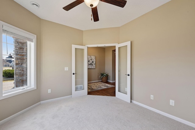 unfurnished bedroom with visible vents, a ceiling fan, french doors, carpet, and baseboards