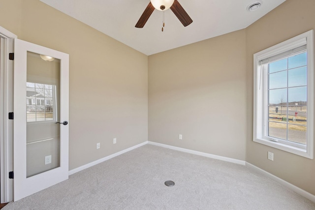 unfurnished room with visible vents, carpet floors, baseboards, and a ceiling fan