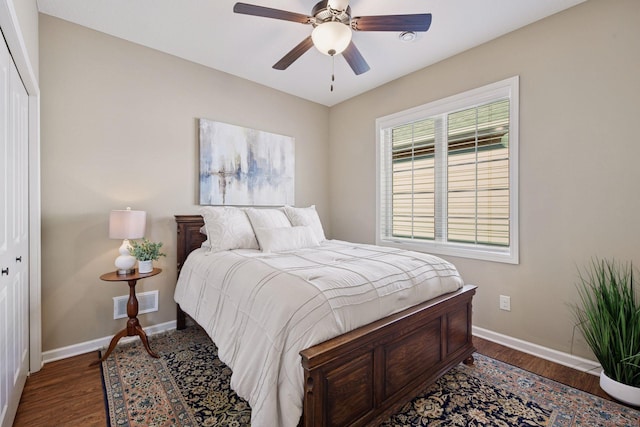 bedroom featuring a closet, baseboards, visible vents, and wood finished floors