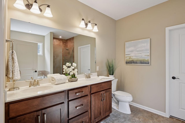 bathroom featuring baseboards, toilet, double vanity, tiled shower, and a sink