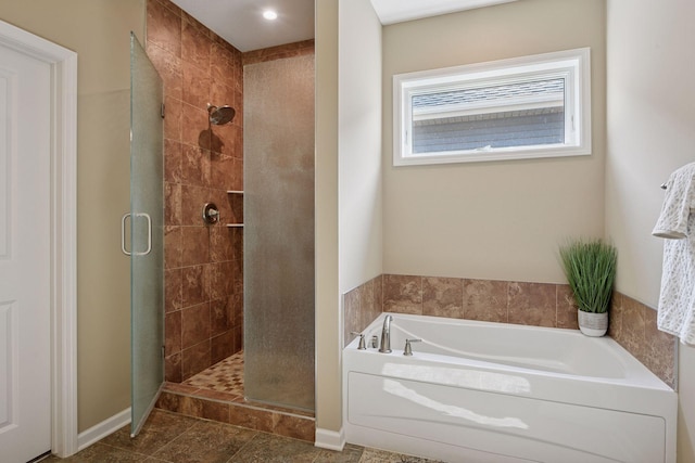 full bathroom featuring baseboards, a garden tub, a stall shower, and tile patterned flooring