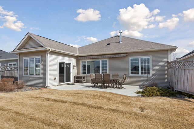 back of house featuring a patio, a yard, fence, and roof with shingles