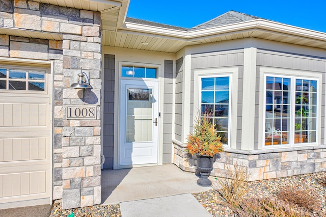 entrance to property with stone siding and roof with shingles