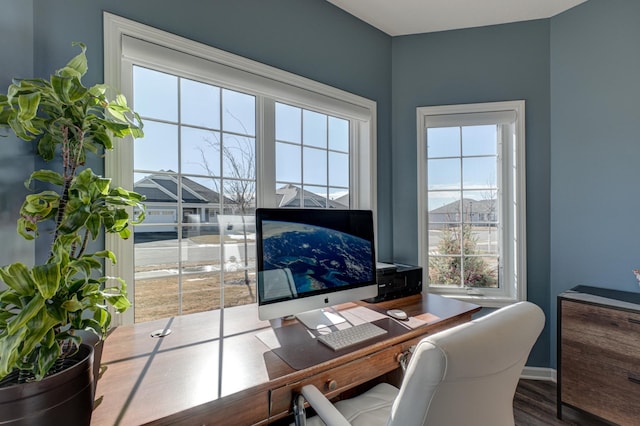 office featuring baseboards, a wealth of natural light, and wood finished floors