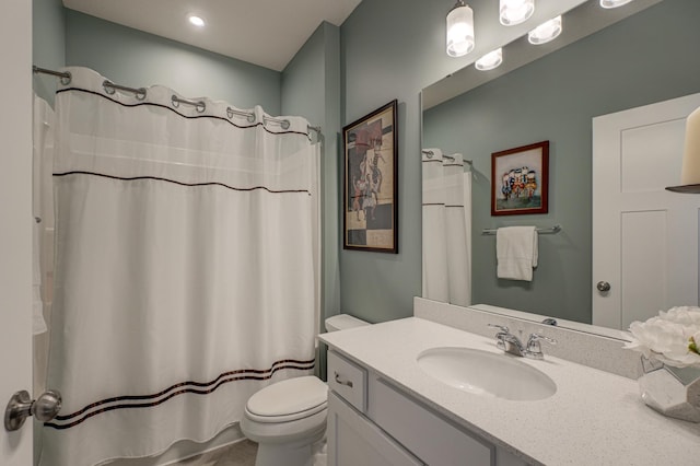 bathroom featuring curtained shower, vanity, and toilet