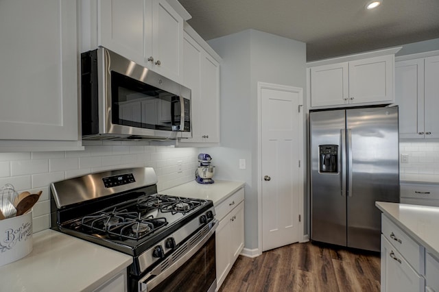 kitchen with white cabinets, appliances with stainless steel finishes, dark wood finished floors, and light countertops