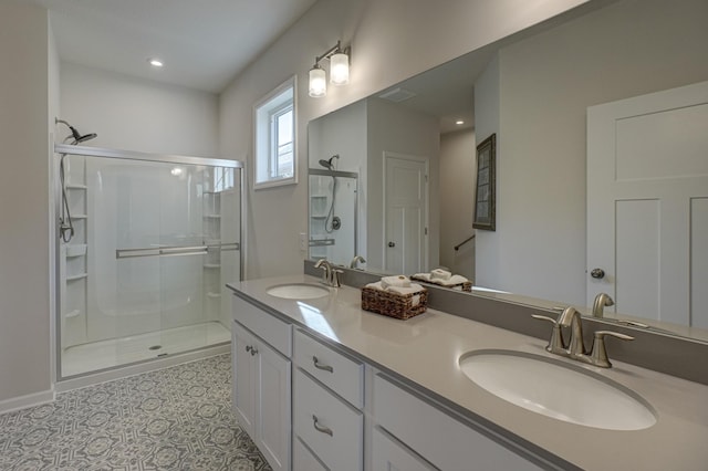 full bathroom with double vanity, a shower stall, and a sink