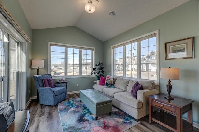 living room with lofted ceiling, visible vents, baseboards, and wood finished floors