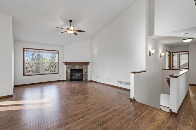 unfurnished living room featuring dark hardwood / wood-style flooring, ceiling fan, and a fireplace