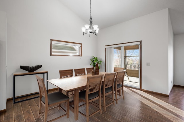 dining space with dark wood-type flooring, an inviting chandelier, and vaulted ceiling