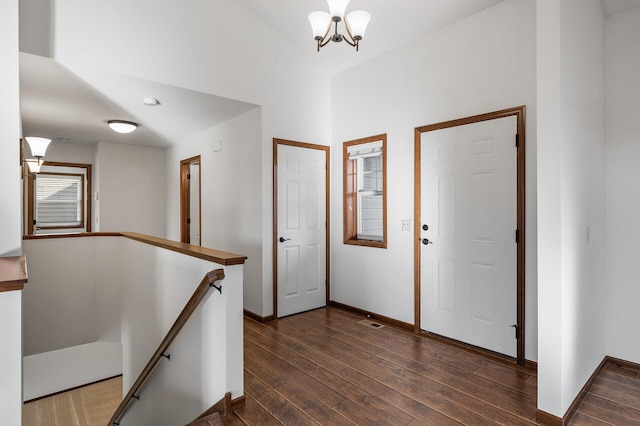 foyer entrance featuring dark wood-type flooring and an inviting chandelier