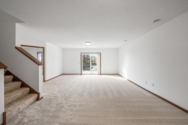 carpeted spare room with a textured ceiling