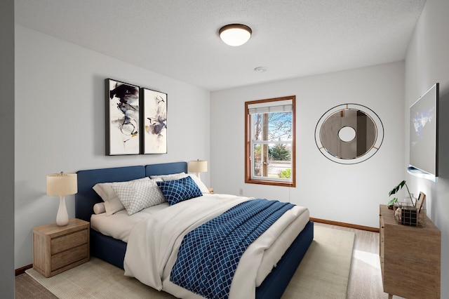 bedroom featuring a textured ceiling and light hardwood / wood-style floors