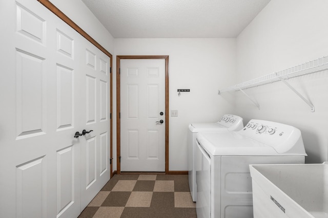 washroom featuring a textured ceiling, sink, and washer and dryer