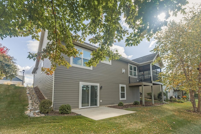 back of property with a lawn, a balcony, and a patio area