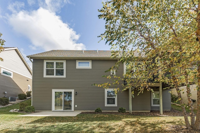 rear view of house featuring a lawn and a patio