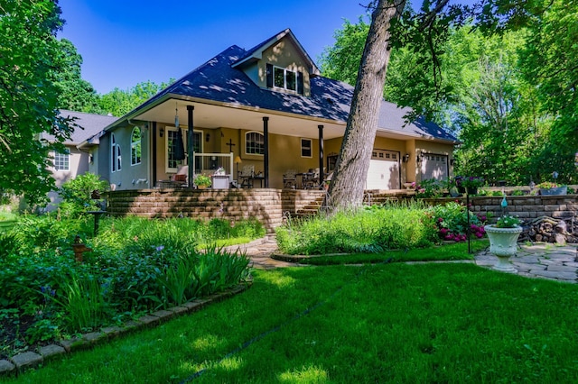 back of property featuring a yard, a porch, and a garage