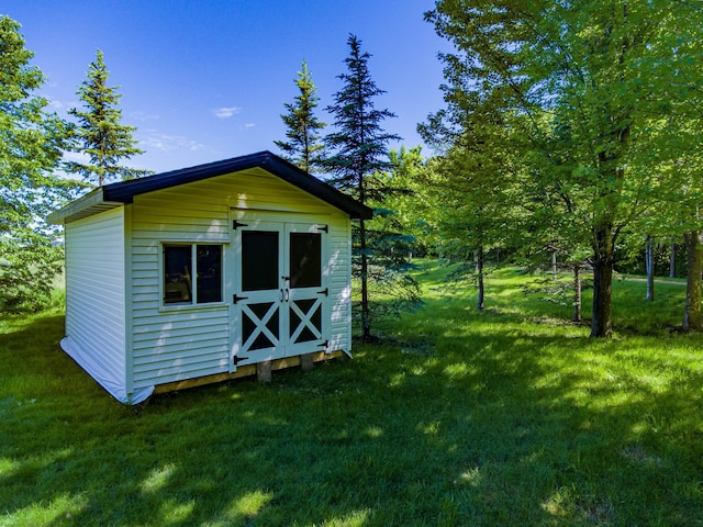 view of outbuilding featuring a lawn