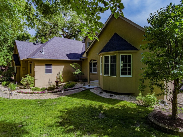 rear view of property featuring a lawn