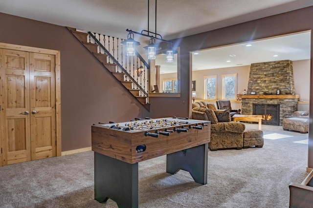 recreation room with carpet floors and a stone fireplace