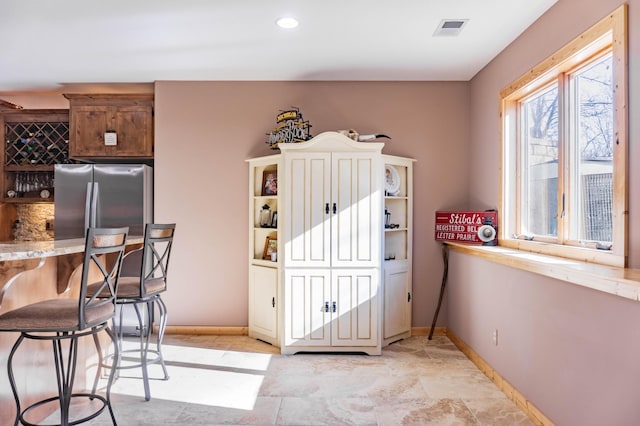 kitchen with stainless steel fridge and tasteful backsplash