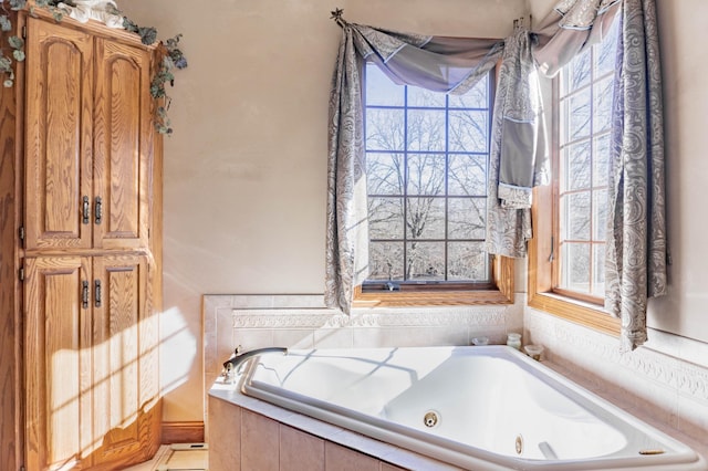 bathroom with plenty of natural light and a relaxing tiled tub