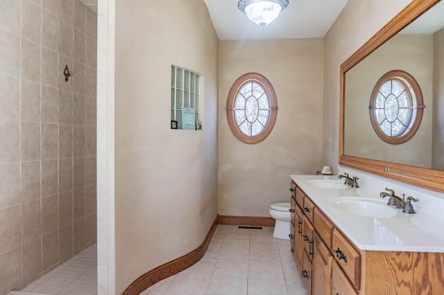 bathroom featuring vanity, tile patterned flooring, toilet, and a healthy amount of sunlight